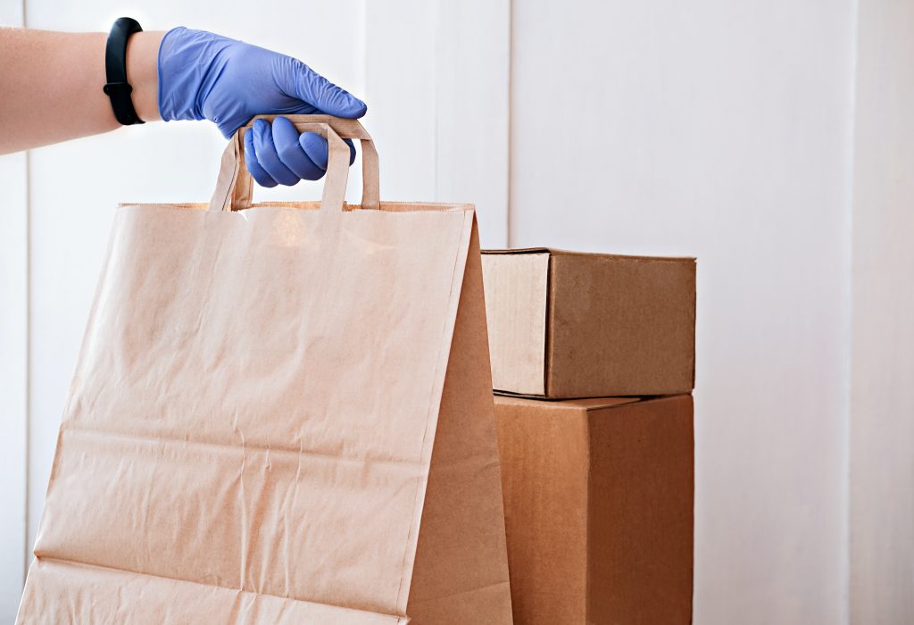 courier delivering boxes. hands holding box with food.