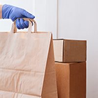 courier delivering boxes. hands holding box with food.
